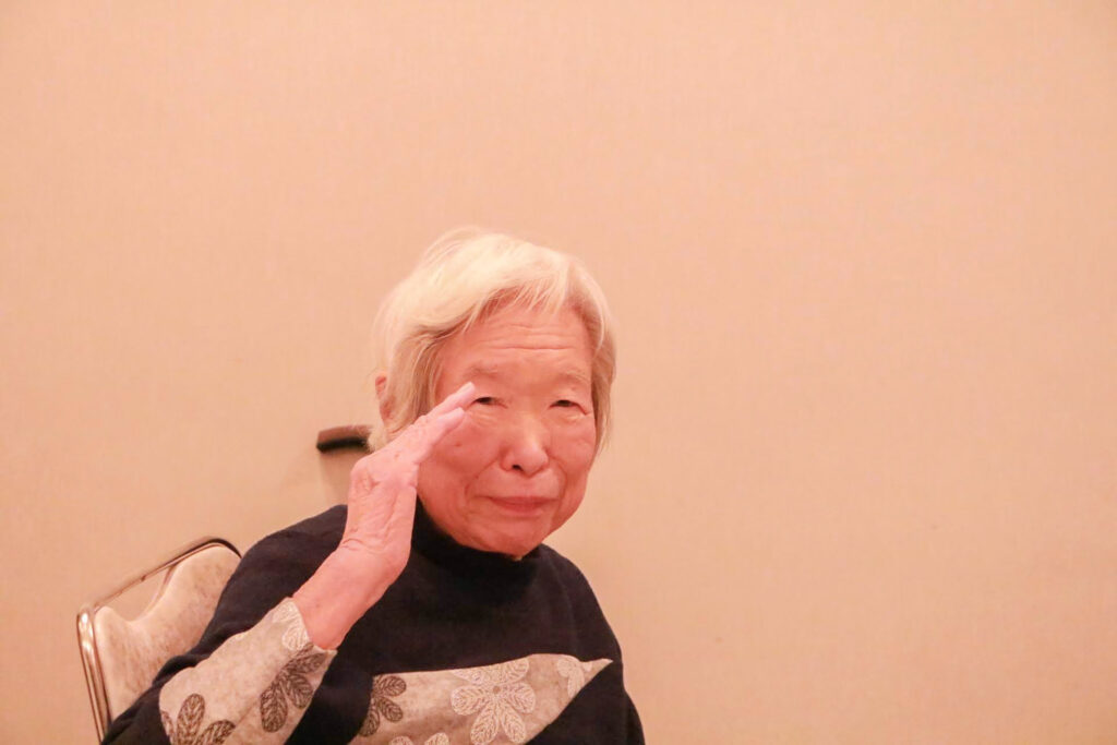 椅子に座り微笑むばあちゃん。