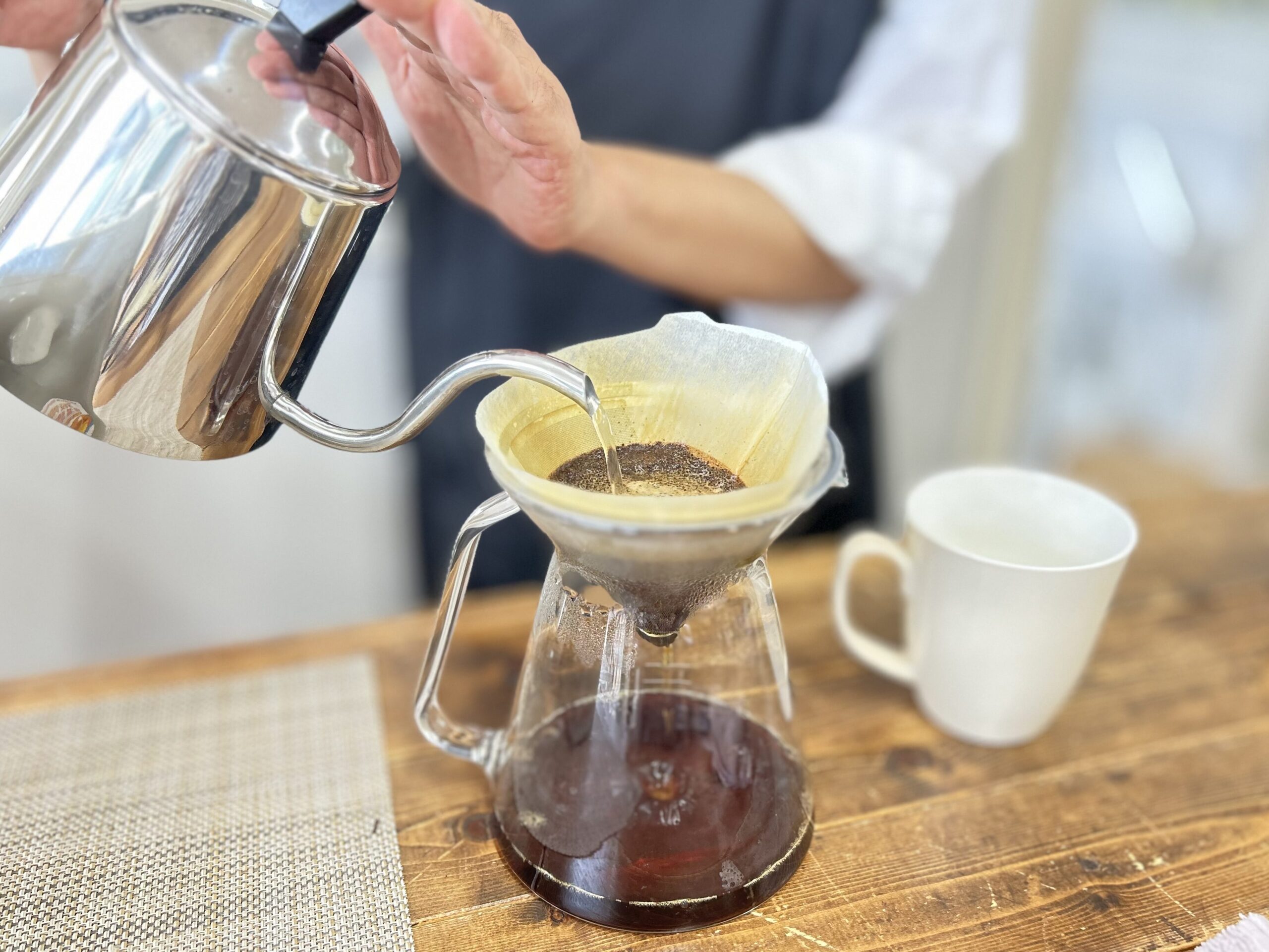 明るい部屋でコーヒーを注ぐおじいさん。コーヒーを嗜むおじいさん。 明るい部屋でコーヒーを注ぐおじいさん。コーヒーを嗜むおじいさん。