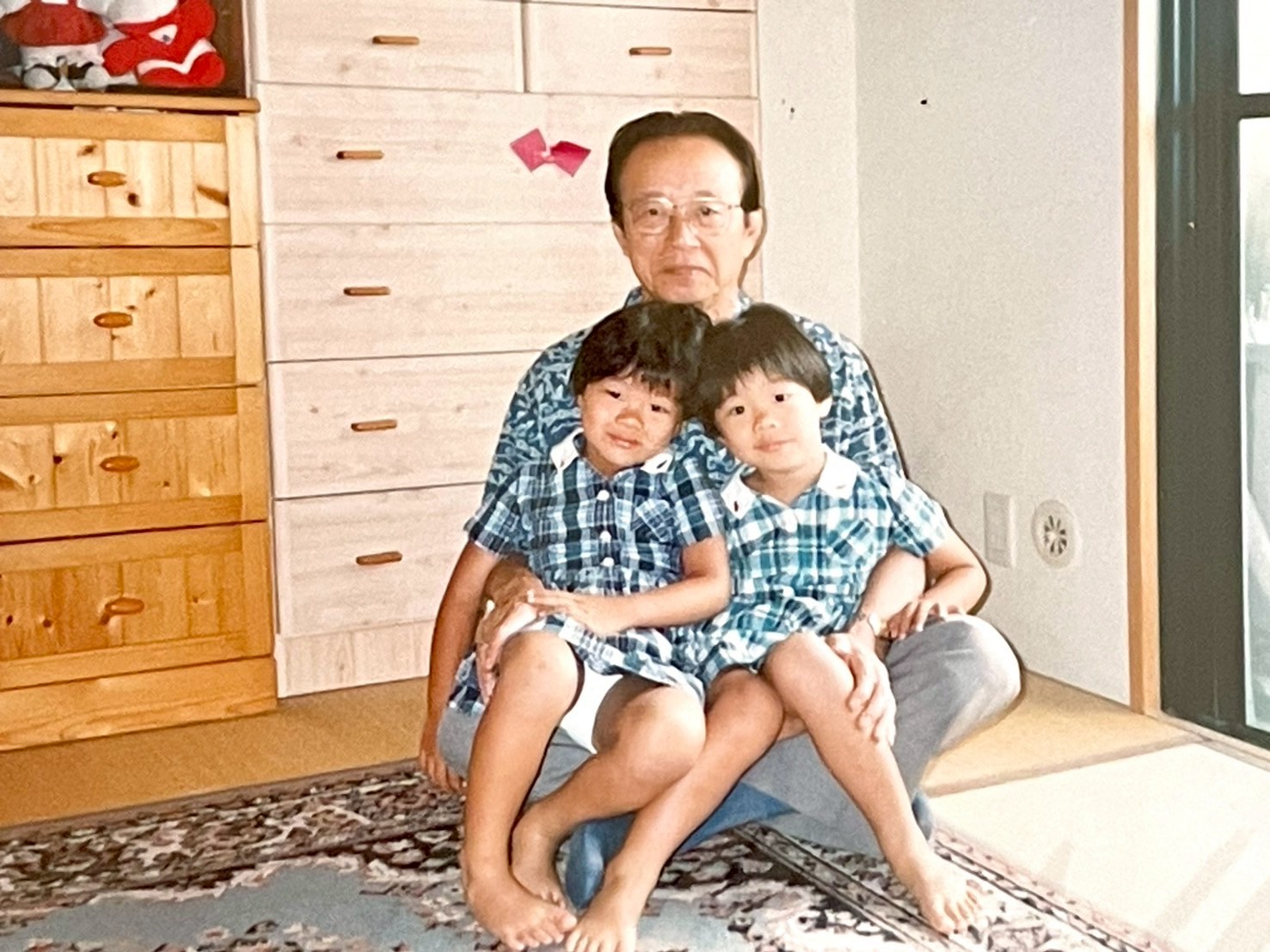 仲良くくっついて座る姉妹と祖父