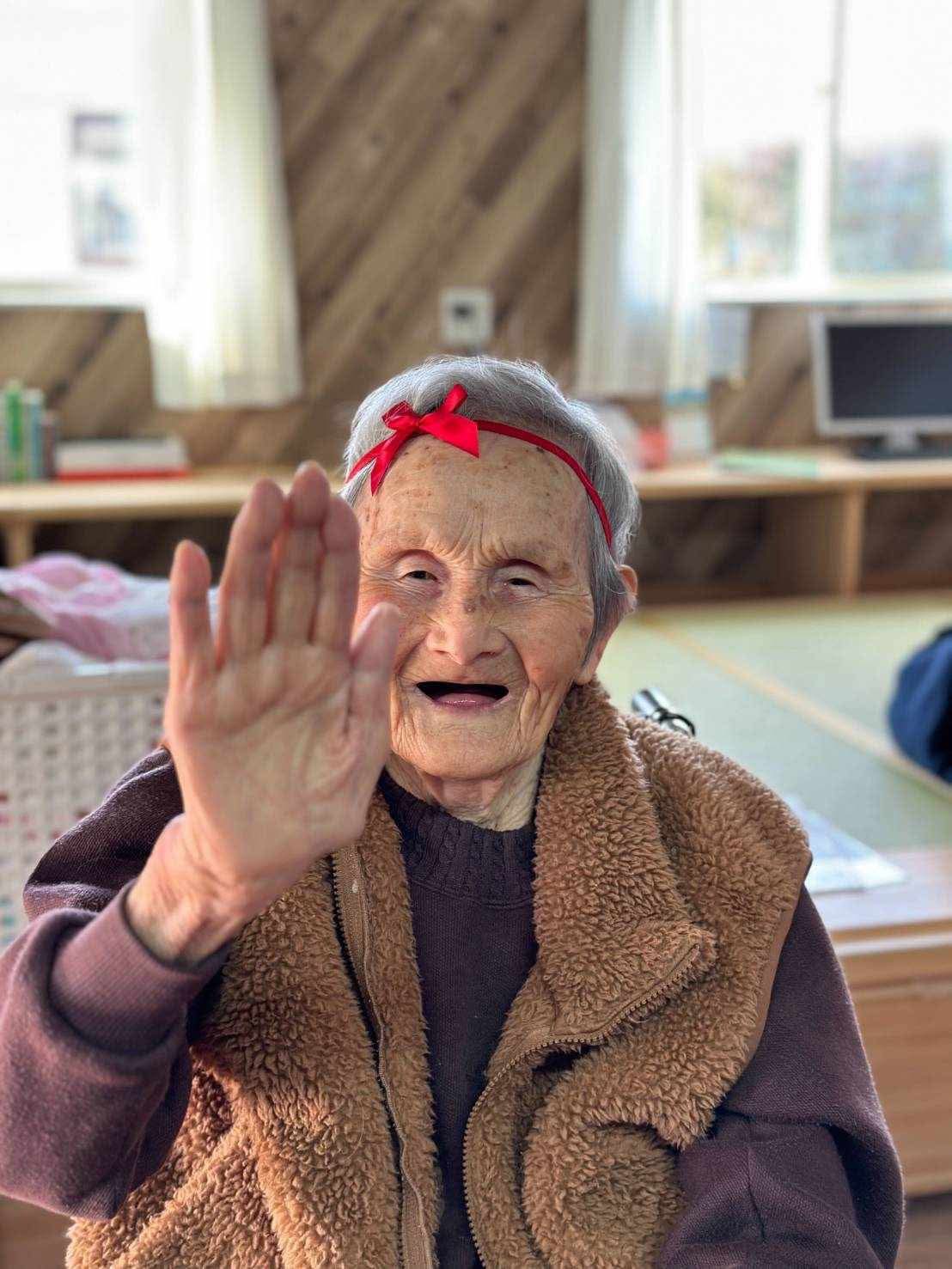赤いリボンをつけて笑顔のフサ子ばあちゃん