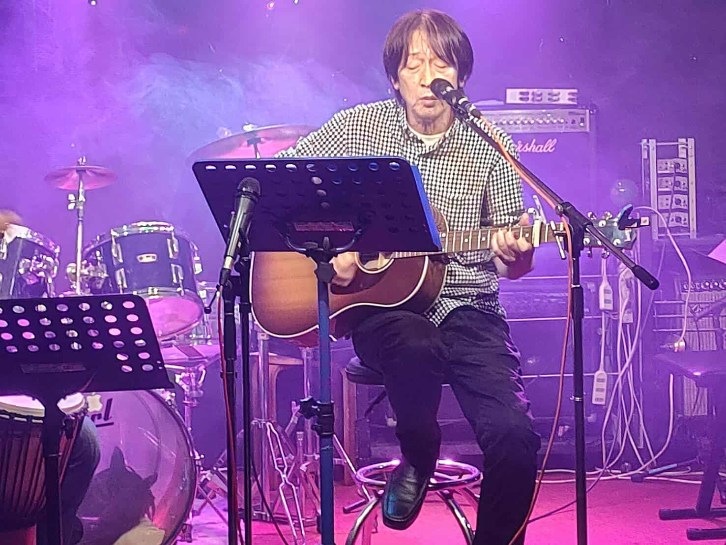 ライブイベントで弾き語りを披露するおじいちゃん