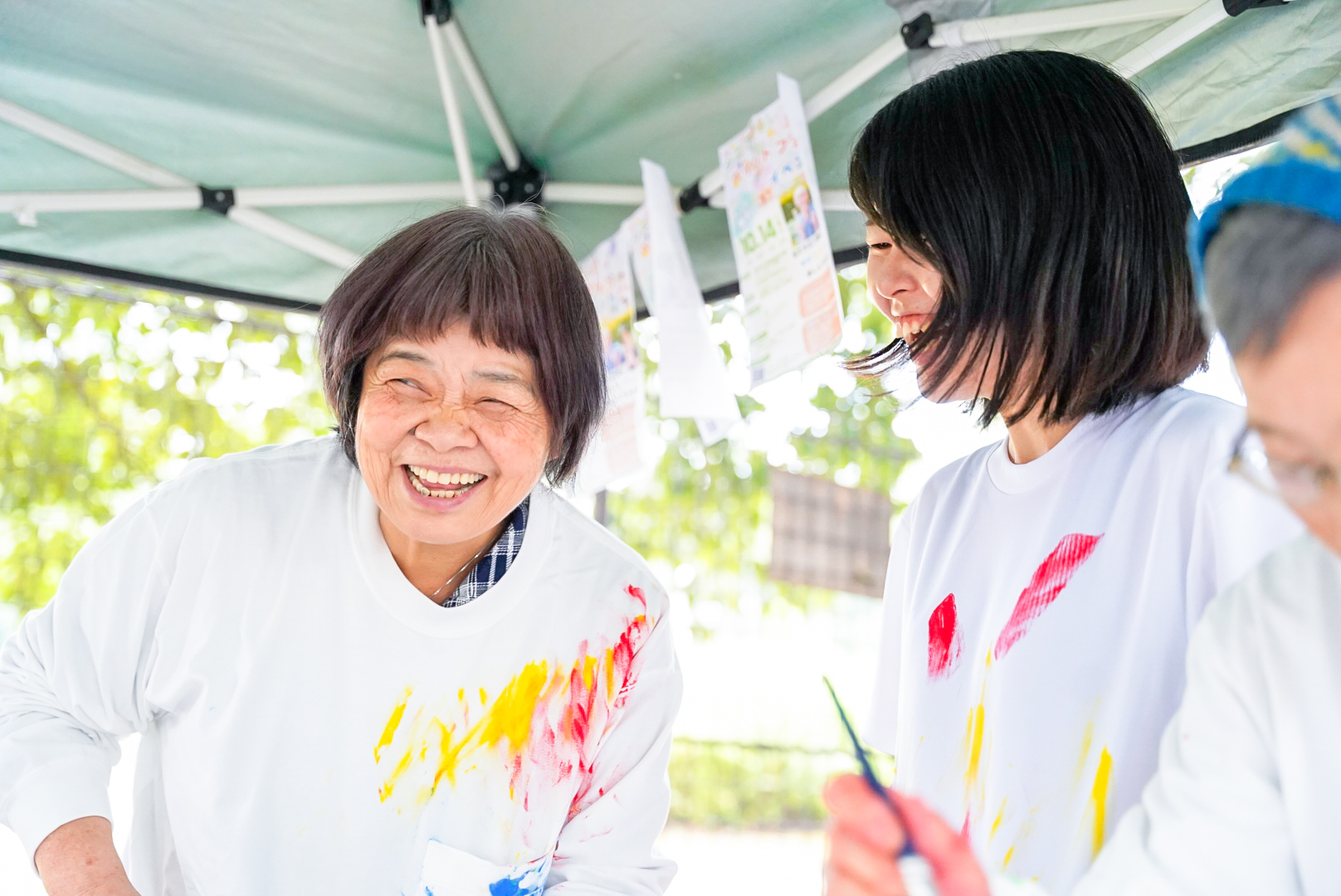 テントの下で笑顔を見せるおばあちゃんとお孫さん