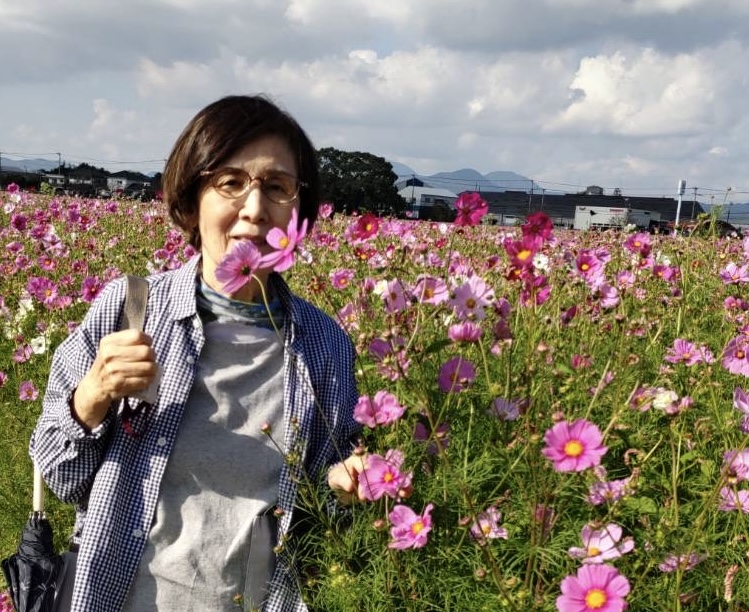 お花畑で微笑むおばあちゃん