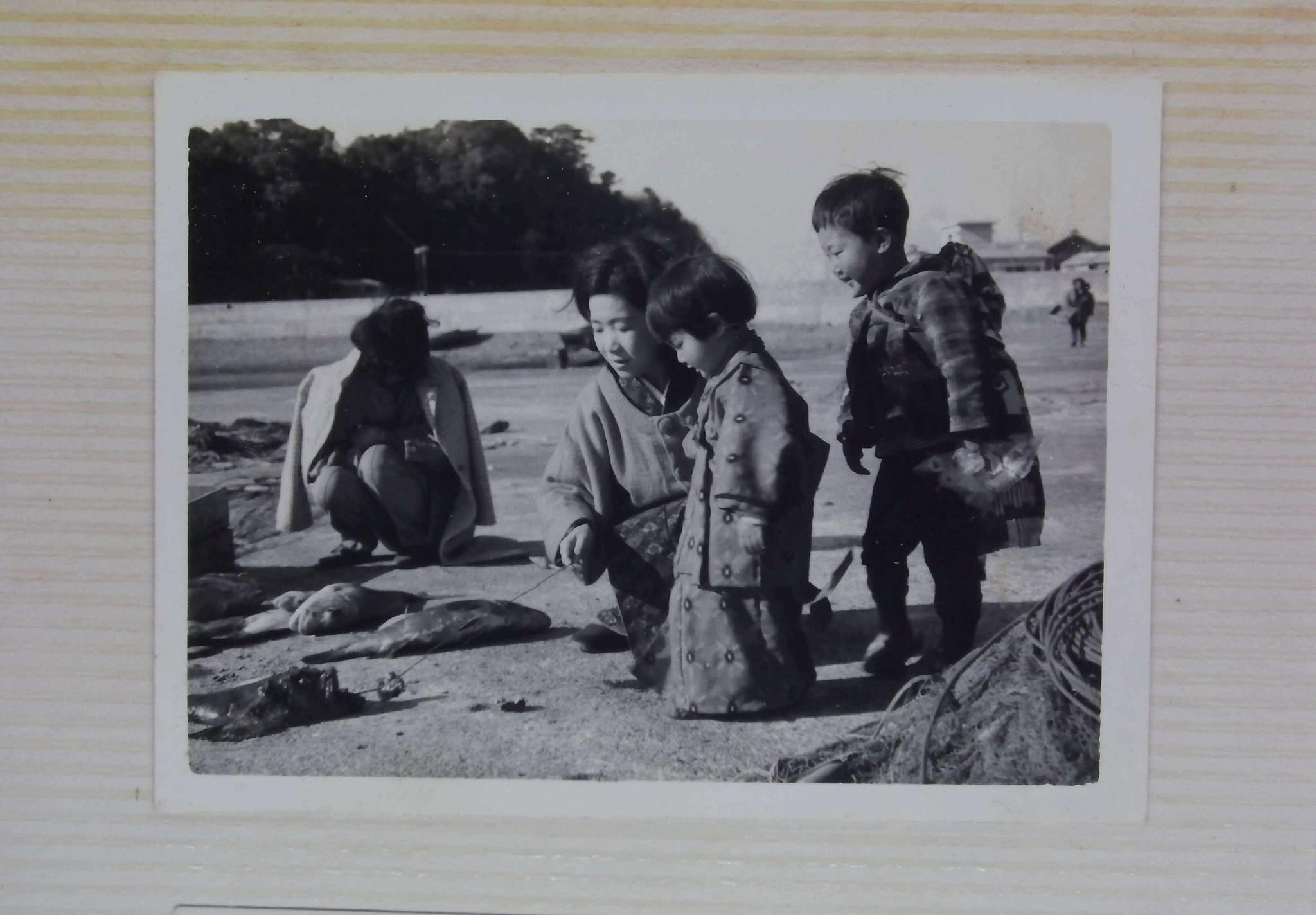 戦時中に幼い子どもたちと食べ物を分け合う、若き日のおばあちゃんの白黒写真