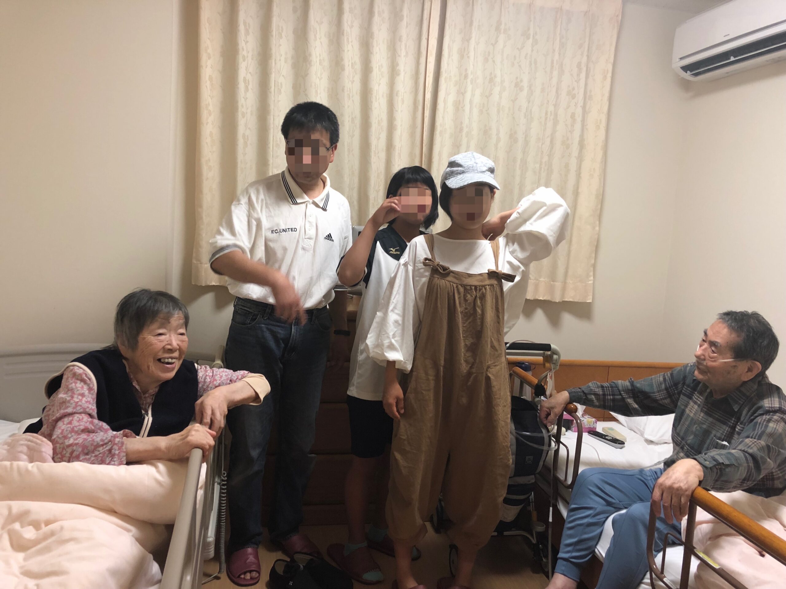 ベッドに座るおじいちゃんおばあちゃんと孫